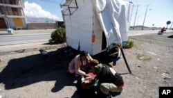 Unos migrantes venezolanos atienden a un compañero, cerca de Colchane, Chile, el 6 de febrero de 2021.