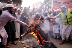 Bangladeshi Muslims protesting the French president’s support of secular laws allowing caricatures of the Prophet Muhammad march burn an effigy of French President Emmanuel Macron in Dhaka, Bangladesh, Nov.2, 2020.