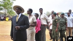 Uganda's President Yoweri Kaguta Museveni, wearing hat at left, stands in a queue as he waits with other voters to place his ballot in Kiruhura district, which is Museveni's home area, at a Polling station about 300 Kms (200 miles) west of Kampala, Ugand