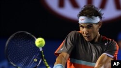 L'Espagne Rafael Nadal renvoie la balle à Gaël Monfils de la France lors de leur troisième match au premier tour du tournoi de tennis Open d'Australie à Melbourne, en Australie, le samedi 18 janvier, 2014. (AP Photo / Aaron Favila)