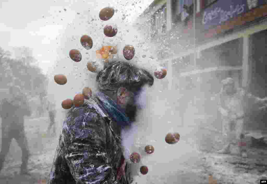 Orang-orang yang mengenakan pakaian militer tiruan mengambil bagian dalam pertarungan tepung &quot;Els Enfarinats&quot; di Kota Ibi, Spanyol tenggara, 28 Desember 2024. (Foto: Jaime Reina/AFP)