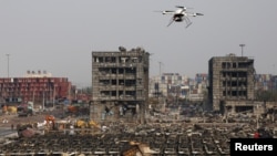 A drone operated by paramilitary police flies over the site of last week's explosions at Binhai new district in Tianjin, China, August 17, 2015.