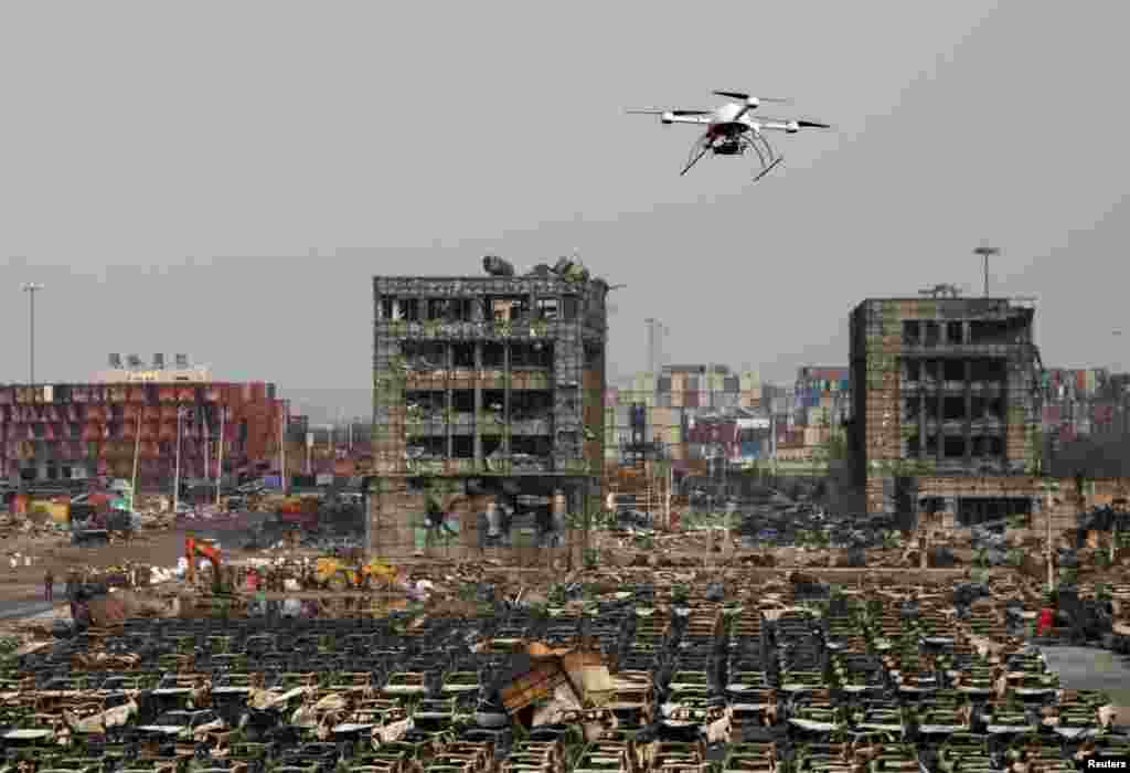 A drone operated by paramilitary police flies over the site of last week&#39;s explosions at Binhai new district in Tianjin, China. Many operations have resumed at China&#39;s Tianjin port, trade sources said, after explosions last week that killed more than 100 people and disrupted business at what is an important oil, gas and bulk import harbor for Asia&#39;s biggest economy.
