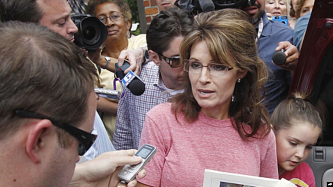 Former Alaska Governor Sarah Palin, holding a booklet depicting Paul Revere, speaks briefly with the media as she tours Boston's North End neighborhood, June 2, 2011 (file photo).