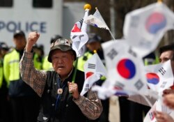 FILE - South Korean activists shout slogans with national flags as police block them from trying to release balloons with leaflets, during a rally at the border city with North Korea, in Paju, South Korea, April 15, 2016.