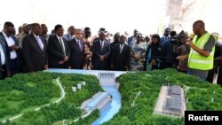 Aliyekuwa rais wa Tanzania John Magufuli akiwa na Waziri wa Umeme na Nishati Jadidifu wa Misri Mohamed Hamed Shaker wakihudhuria uzinduzi wa mradi wa Umeme wa Rufiji Hydro Power Tanzania, tarehe 26, Julai 2019. Picha na shirika la habari la Reuters. 