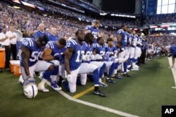 Members of the Indianapolis Colts kneel during the nation anthem before an NFL football game against the Cleveland Browns in Indianapolis, Indiana, Sept. 24, 2017.