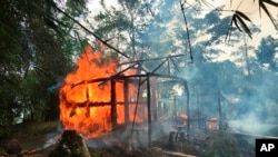 FILE - Houses burn in Gawdu Zara village, northern Rakhine state, Myanmar, Sept. 7, 2017.