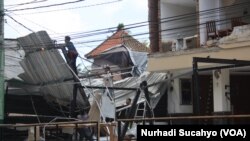 Sejumlah pekerja membersihkan bagian hotel yang rusak parah di kawasan wisata Senggigi, Lombok, 9 Agustus 2018. (Foto: Nurhadi Sucahyo)