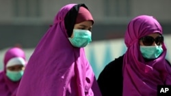 FILE - Muslim pilgrims wear surgical masks to prevent infection from respiratory virus known as the Middle East respiratory syndrome (MERS) in the holy city of Mecca, Saudi Arabia. 