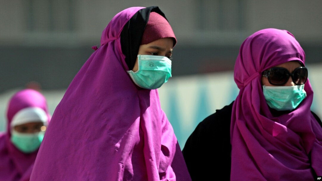 Muslim yang beribadah umrah menggunakan masker wajah untuk mencegah infeksi virus penyakit pernafasan MERS di Mekah, Arab Saudi, Mei 2014.