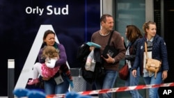 Travelers evacuate Orly airport, south of Paris, March, 18, 2017. Soldiers at Paris' busy Orly Aiport shot and killed a man who wrestled one of their colleagues to the ground and tried to steal her rifle Saturday, officials said.