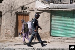 An Afghan security officer arrives at an area near a house where attackers are hiding, in Kabul, Afghanistan, Aug. 21, 2018. Russia was set to host Taliban and Afghan government representatives for talks starting September 4, but was forced to postpone after Afghan President Ashraf Ghani declined the invitation.