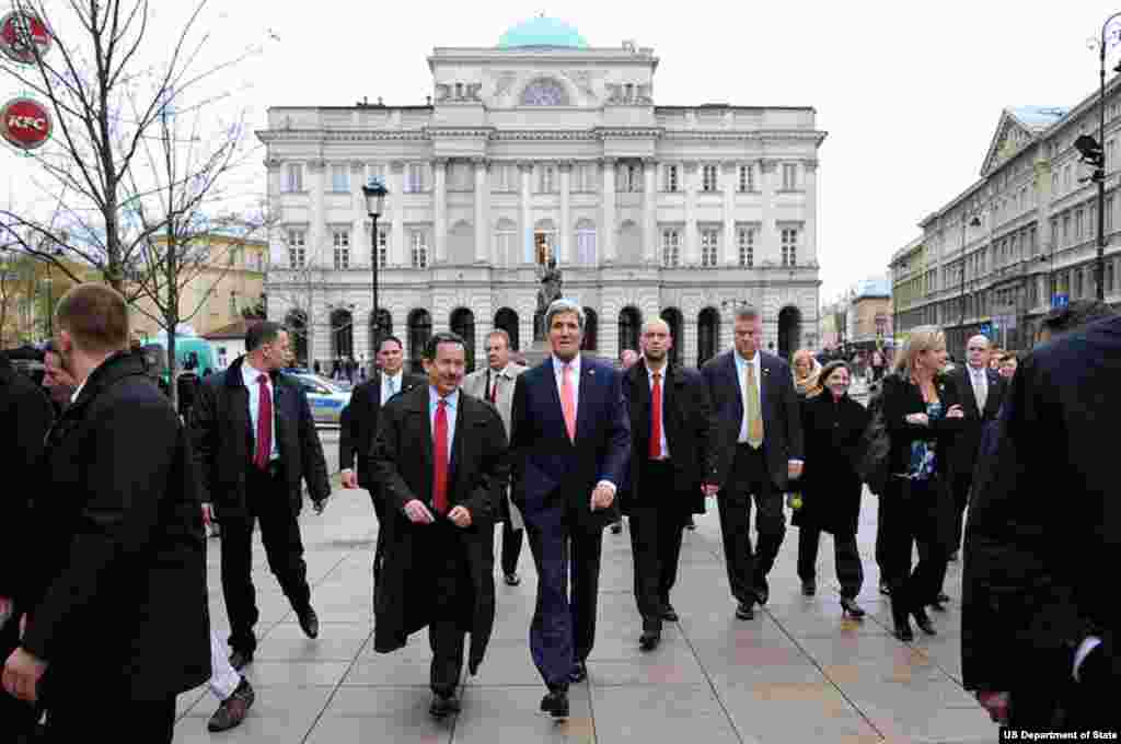 U.S. Secretary of State John Kerry and U.S. Ambassador to Poland Stephen Mull walk away from a statue of philosopher Copernicus as they begin a walking tour of downtown Warsaw, Poland, on November 5, 2013. 