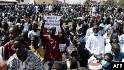 FILE - A man holds a sign reading 'My son will not be an homosexual' during a protest called by religious associations against homosexuality on May 23, 2021, on the Obelisque square in Dakar, Senegal. 