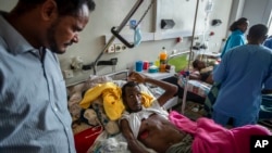 FILE - Farmer Teklemariam Gebremichael, who said he was shot by Eritrean forces in Enticho six months before and was still recovering, speaks to a doctor, left, at the Ayder Referral Hospital in Mekele, in Ethiopia's Tigray region, May 6, 2021.