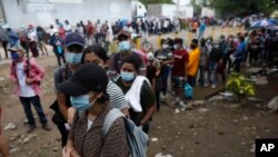 Los nicaragüenses esperan en la fila para recibir una dosis de la vacuna COVID-19 en un centro de vacunación en Guasaule, Honduras, el jueves 28 de octubre de 2021.