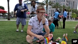 Johnathan Dalton breaks down as he places flowers on a makeshift memorial in memory of two of his friends who were killed during a fatal shooting at the Pulse Orlando nightclub in Orlando, Fla., June 13, 2016.