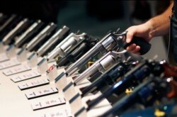 FILE - Handguns are displayed at the Smith & Wesson booth at the Shooting, Hunting and Outdoor Trade Show in Las Vegas, Jan. 19, 2016.