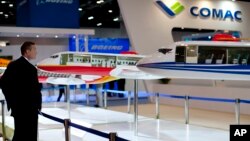 Seorang pengunjung mengamati sebuah model pesawat jet komersial pertama China, ARJ21 di sebuah pameran dirgantara di Beijing, Rabu (25/9).