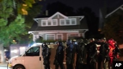 Portland police search for protesters in the Laurelhurst neighborhood after dispersing a crowd of about 200 people from in front of the Multnomah County Sheriff's Office in Portland, Oregon, Aug. 8, 2020.