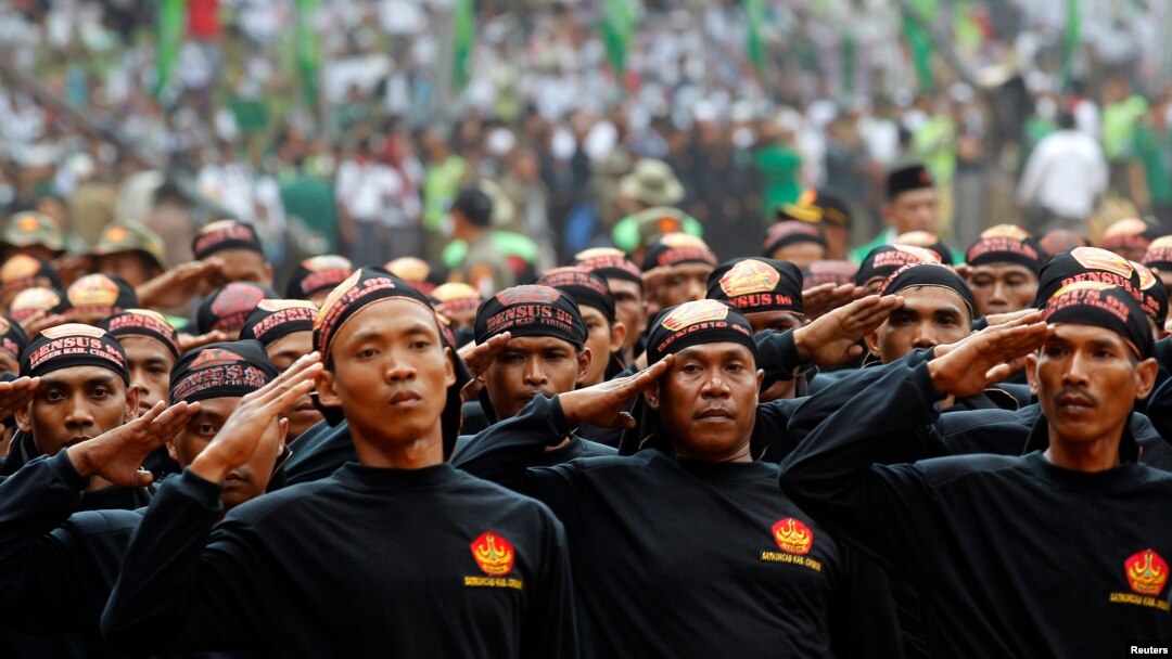 Members of Banser, the security unit of Indonesia's largest Muslim organization, Nahdlatul Ulama (NU), salute guests during a parade to commemorate the organization's 85th anniversary in Gelora Bung Karno Stadium in Jakarta, July 17, 2011. 