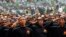 Members of Banser, the security unit of Indonesia's largest Muslim organization, Nahdlatul Ulama (NU), salute guests during a parade to commemorate the organization's 85th anniversary in Gelora Bung Karno Stadium in Jakarta, July 17, 2011. 