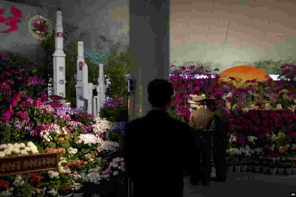 Two military officers admire displays at a flower show featuring thousands of Kimilsungia flowers, named after the late North Korean leader Kim Il Sung, Pyongyang, April 12, 2013. 