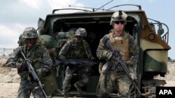 FILE - U.S. and South Korean Marines run from a South Korean assault amphibious vehicle during joint military exercises in Pohang, south of Seoul, April 26, 2013.