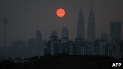 A general view shows Malaysia's landmark Petronas Twin Towers (2nd R) and Kuala Lumpur Tower (L) as a layer of haze covers the city during sunset in Kuala Lumpur, March 30, 2016.