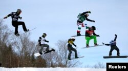 FILE - Snowboarders compete during the men's Snowboard-Cross eighth-finals at the FIS Snowboard World Championships in Stoneham, Quebec, Jan. 26, 2013.