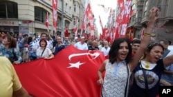 Protesters shout slogans as they hold a Turkish flag during the third day of nationwide anti-government protest at the Taksim square in Istanbul, June 2, 2013.