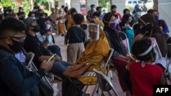 Orang-orang menunggu giliran tes usap (swab test) Covid-19 gratis di Surabaya, 29 Juni 2020. (Foto: Juni Kriswanto/AFP) 