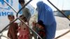 Famille afghane dans un centre de rapatriement du HCR, à Peshawar, au Pakistan, le 16 août 2017. (AP Photo/Muhammad Sajjad)