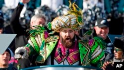 In this Feb. 8, 2018, file photo, Philadelphia Eagles center Jason Kelce, wearing a Mummers costume, speaks at the conclusion of the NFL team's Super Bowl victory parade in front of the Philadelphia Museum of Art in Philadelphia. (AP Photo/Alex Brandon)