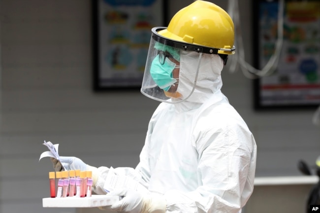 Seorang petugas kesehatan membawa sampel darah saat tes cepat virus corona di sebuah rumah sakit di Jakarta, 28 April 2020. (Foto: AP))