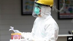 Seorang petugas kesehatan membawa sampel darah saat tes cepat virus corona di sebuah rumah sakit di Jakarta, 28 April 2020. (Foto: AP))