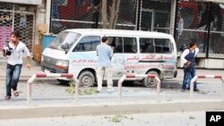 Journalists stand near a bullet-ridden mini-van during an on-going attack in Kabul on September 13, 2011.