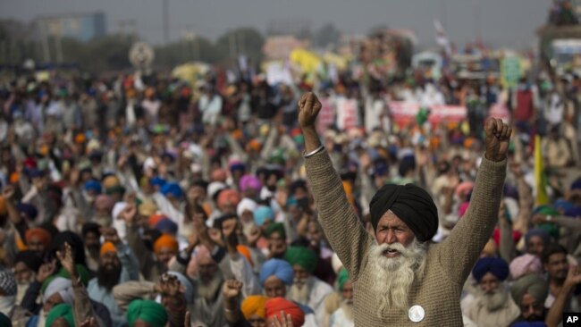 An elderly farmer shouts slogans as others listen to a speaker as they block a major highway during a protest to abolish new farming laws they say will result in exploitation by corporations. (AP Photo/Altaf Qadri)