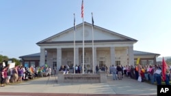 A gathering of same sex marriage supporters, left, and supporters of Rowan County Clerk Kim Davis, right, face off in front of the Rowan County Courthouse in Morehead, Ky., Sept. 1, 2015. 