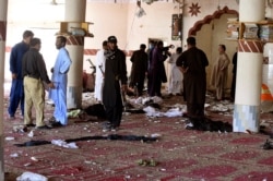 People gather at a mosque following a bomb blast in Kuchlak near Quetta, Pakistan, Aug. 16, 2019.