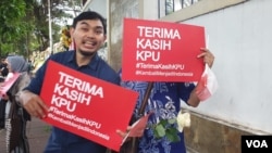 Peserta aksi damai memberikan dukungan kepada Komisi Pemilihan Umum (KPU) di depan kantor KPU pada Senin (22/4). (Foto: VOA/Sasmito)