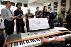 FILE - Members of the Butterfly Music Transgender Chorus rehearse at a church in Cambridge, Mass., Oct. 7, 2015. The chorus is led by Sandi Hammond, a vocal coach who also trains members how to adjust their voices safely when they transition.