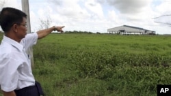 မင်္ဂလာဒုံ စက်မှုဇုံစီမံကိန်းကြောင့် ဇေကမ္ဘာကုမ္ပဏီရဲ့ လယ်မြေအသိမ်းခံလိုက်ရသူ မြေပိုင်ရှင်တဦးက သူ့ရဲ့ အသိမ်းခံလိုက်ရတဲ့ လယ်နေရာကို ညွန်ပြနေပုံ 