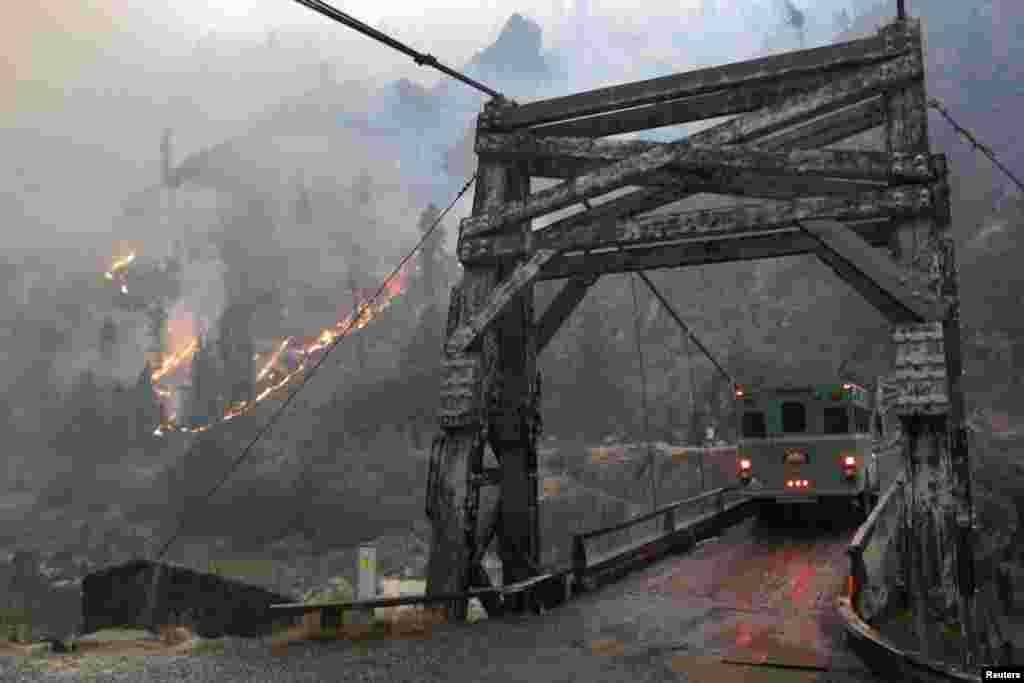 미국 아이다호주 리긴스에서 새먼강을 가로지르는 매닝 다리 뒤로 산불이 발생했다.