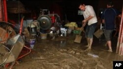 Taiwanese people scrape the mud off their house following flood and landslides triggered by typhoon Nanmadol in Laiyi, Pingtung County, Southern Taiwan, Monday, Aug. 29, 2011. Nanmadol slammed into Taiwan, closing schools, workplaces and government office