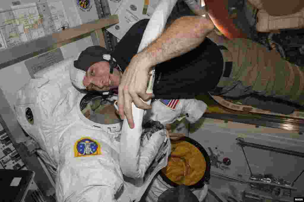 Astronaut Mike Hopkins checks out the spacesuit he will be wearing on a spacewalk at the International Space Station, in this undated handout photo from NASA.