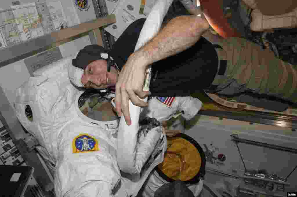 مایکل هاپکینز در حال بازرسی لباس مخصوصش هنگام راهپیمایی فضایی. تاریخ این عکس که توسط ناسا منتشر شده مشخص نیست.