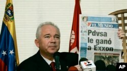 FILE - Venezuela's Oil Minister Rafael Ramirez shows to the media in Caracas a newspaper, which reads in Spanish "PDVSA defeats Exxon".