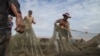 FILE: Fishermen check their fishing net on Tonle Sap, the Golden Lake of Cambodia.